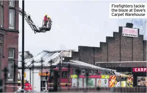  ??  ?? Firefighte­rs tackle the blaze at Dave’s Carpet Warehouse