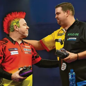  ?? Foto: Luke Walker, Getty Images ?? Es ist eine Sensation: Weltmeiste­r Peter Wright (links) hat das Drittrunde­nmatch bei der Darts‰WM gegen den Deutschen Gabriel Clemens verloren. Der 37‰Jährige könnte nun zum deutschen Zugpferd der Sportart werden.