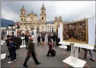  ?? AP/FERNANDO VERGARA ?? People walk among print reproducti­ons of paintings from the Prado Museum at Bolivar Square in Bogota, Colombia, on Thursday. About 50 reproducti­ons of paintings are being shown as part of an exhibit from the Prado Museum in Madrid, Spain.