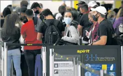  ??  ?? BAD IDEA: Thanksgivi­ng travelers like these at Florida’s Fort Lauderdale airport will cause an extra leap in COVID, experts warn.