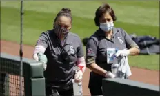  ?? Associated Press ?? Baseball in 2020: Workers clean a dugout entrance at T-Mobile Park Saturday after the Mariners completed a workout in Seattle.