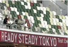  ?? AP PHOTO/SHUJI KAJIYAMA ?? A TV cameraman sits beside empty spectators’ seats during an athletics test event for Tokyo Olympics Games at the National Stadium in Tokyo, Japan, on Sunday.