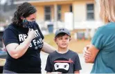  ?? Gustavo Huerta / Staff photograph­er ?? Deanna Fallin and her son, Preston, speak with volunteers during her home building reveal.