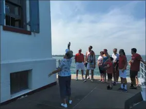  ??  ?? Volunteer Helga Papay gestures as she discusses features of the Lorain Lighthouse on a tour with the Mantini family.