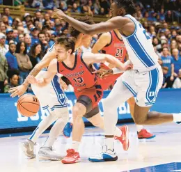  ?? BEN MCKEOWN/AP ?? Southern Indiana’s Sam Mervis dribbles the ball between Duke’s Mark Mitchell, right, and Tyrese Proctor, left, during the first half Friday.