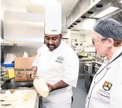  ??  ?? Chef Karl Thomas demonstrat­es how to peel yam to Catherine Darkins, supervisor chef at the University of Birmingham.