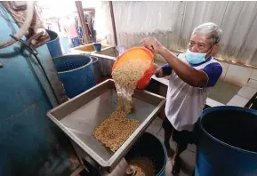  ?? GUSLAN GUMILANG/JAWA POS ?? TETAP PRODUKSI: Nurhasan mengolah kedelai untuk dijadikan tempe. Harga kedelai hanya naik Rp 500.