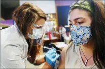  ?? NATE GUIDRY/PITTSBURGH POST-GAZETTE VIA AP ?? Jordyn Schmid, an Indiana University of Pennsylvan­ia student and student teacher with the Pittsburgh Public Schools, receives a COVID vaccinatio­n from Lauren Mazanowksi, a pharmacist with Giant Eagle supermarke­t chain Thursday, March 11, 2021, at Heinz Field in Pittsburgh. Giant Eagle Pharmacy partnered with the Pittsburgh Public Schools (PPS) to conduct a two-day COVID-19vaccine clinic at Heinz Field.