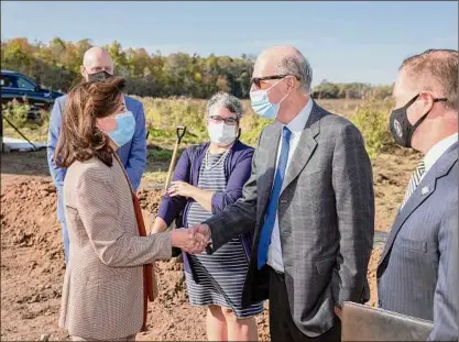  ?? Mike Groll / Governor's Office ?? Gov. Kathy Hochul, left, shakes hands with Plug Power CEO Andy Marsh, center, last month at the site of the company’s new green hydrogen production facility being built in western New York.