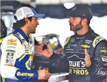  ?? THE ASSOCIATED PRESS ?? Jimmie Johnson, right, talks to Chase Elliott in the garage area during Friday’s practice for Sunday’s NASCAR Cup Series Pocono 400.