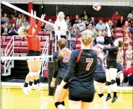  ??  ?? Sophomore Josey Goldberg (No. 7) and junior Kynley Burton (No. 24) watch as senior Maria Socha (No. 15) prepares to hit the volleyball last Tuesday.