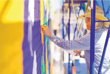  ?? ADOLPHE PIERRE-LOUIS/JOURNAL ?? Visual artist PAZ sketches a detail on his “In the Garden of Sharing” mural on the east wall of the Albuquerqu­e Community Foundation. The mural was created with the participat­ion of the Jennifer Riordan “Sparkle” Fund and the Albuquerqu­e Community Foundation.