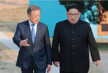  ?? (Reuters) ?? SOUTH KOREAN President Moon Jae-in and North Korean leader Kim Jong-un walk together last month at the truce village of Panmunjom inside the demilitari­zed zone separating the two Koreas.