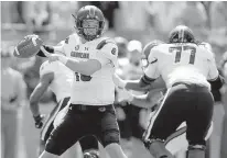  ?? AP Photo/Bob Leverone ?? South Carolina’s Jake Bentley, left, aims a pass as his line keeps the North Carolina State defense contained in the first half Saturday in Charlotte, N.C.