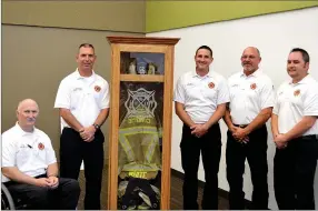  ?? Sierra Bush/Herald-Leader ?? From left to right: Siloam Springs Fire Department EMS Director Brent Ford, Deputy Chief John Vanatta, Fire Marshal Dustin Kindell, former Deputy Chief Travis White and Chief Jeremy Criner pose around a memorial honoring White’s 24 years of service to the SSFD during his retirement party May 17.