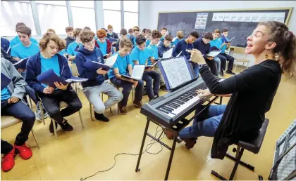  ?? JOHN MAHONEY ?? Isabelle Vandebonco­eur helps the boys’ choir of Les Petits Chanteurs de Laval hit all the right notes in rehearsal.