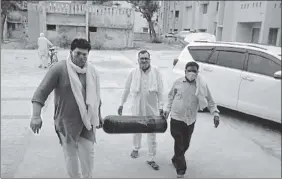  ?? HT PHOTO ?? Gaurav Tikait (in saffron kurta) and others bringing an oxygen cylinder to PHC in Sisauli town of Muzaffarna­gar.