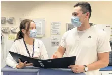  ?? LYNN GILBERT • NOVA SCOTIA HEALTH ?? Registered nurses Brittani Andrews, left, and Tyrel Carroll review a patient chart on Unit 4A, a medical unit at Cape Breton Regional Hospital. There are more than 1,300 nurse vacancies province-wide, including almost 300 in Cape Breton.