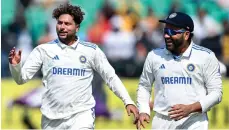  ?? AFP ?? India’s Kuldeep Yadav, left, celebrates with captain Rohit Sharma after taking the wicket of England captain Ben Stokes