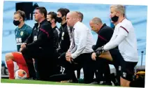  ?? REUTERS ?? Sending the right message: Dyche takes a knee with the rest of his staff at the Etihad