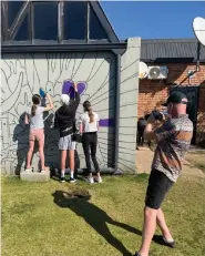  ??  ?? Jono Hornby in action behind the scenes as the community colours the wall.