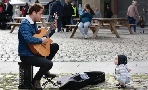  ?? PHOTO: FRANK McGRATH ?? Play it again: Elevenmont­h-old Eli McGovern from Dunboyne, Co Meath, watches Jose Pedro Jobim from Brazil at the Busker Fleadh at Smithfield Square in Dublin.