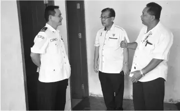  ??  ?? Jamit (centre) with Riyong (on his left) and Pasang in front of the public toilets which are now clean and tidy.