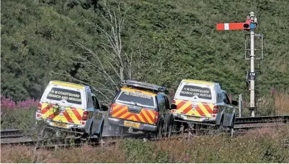  ?? PHOTOS. PA ?? Right: Access to the crash site in a steep valley was very difficult. This trio of Coatguard vehicles is bumping its way north from Carmont straddling the Up Main line. In the background, Carmont‘s 13 signal guards the entrance to the section to Stonehaven.