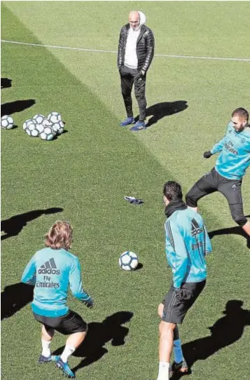  ??  ?? Los jugadores del Real Madrid entrenan bajo la mirada de Zidane