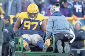  ?? JIM MATTHEWS/USA TODAY NETWORK-WISCONSIN ?? Packers defensive tackle Kenny Clark (97) gets carted off the field after injuring his ankle Sunday against the Ravens.