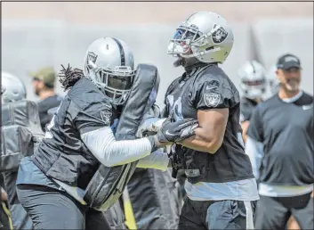  ?? L.E. Baskow Las Vegas Review-journal @Left_eye_images ?? Defensive linemen Darius Philon, left, and Clelin Ferrell perform a drill Wednesday during the Raiders’ voluntary organized team activities session.