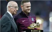  ??  ?? GOLDEN BOY: Rooney received a commemorat­ive boot from Sir Bobby Charlton at Wembley (left) after breaking his England scoring record