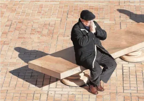  ?? VALERIO MERINO ?? Un hombre se suena la nariz sentado en un banco de la zona turística de Córdoba