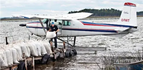  ??  ?? Sacks of wild rice are loaded by bush pilot Joel Cook onto a plane at Montreal Lake. Provincial regulation­s stipulate that only northern residents can hold leases on lakes where wild rice grows.