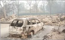  ??  ?? The burned remains of a car sits in the driveway of a home near the Silverado Country Club and Resort Tuesday in Napa, Calif.