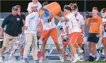  ?? KARL MERTON FERRON/STAFF ?? McDonogh boys lacrosse coach Andy Hilgartner, getting an ice bath after the Eagles beat Calvert Hall for the MIAA A Conference title in May, is excited to see how his senior class responds to the expectatio­ns as they seek a three-peat.