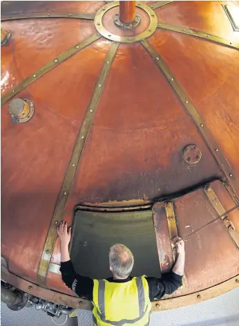  ??  ?? FIRING UP: Employee Derek Laurie inspects the ‘Mash Tun’, which is used in the first stage of whisky production, at the Auchentosh­an Distillery near Glasgow.