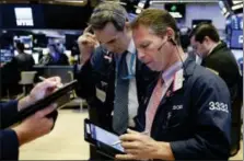  ?? RICHARD DREW — THE ASSOCIATED PRESS ?? Traders Gregory Rowe, center, and Robert Charmak work on the floor of the New York Stock Exchange, Monday.