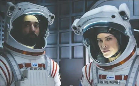  ?? DIYAH PERa/NETFLIX ?? Among the many space series available for streaming is the short-lived Away, starring Ray Panthaki, left, and Hilary Swank.