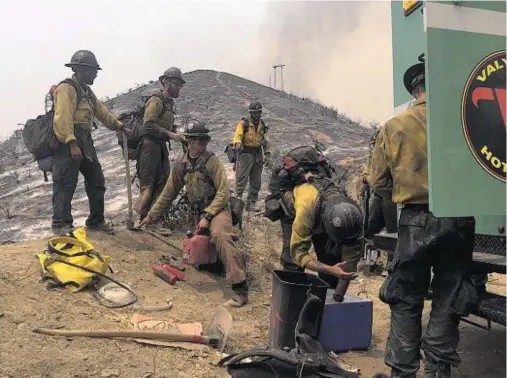  ??  ?? HOT WORK: Forest Service firefighte­rs prepare to head out again near the Wildlife Waystation in Santa Clarita