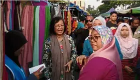  ??  ?? Campaign by night: Maria meeting with voters at a ‘pasar malam’ in Petaling Jaya, Selangor.