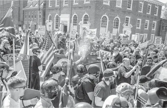  ?? EDU BAYER/THE NEW YORK TIMES ?? White supremacis­ts violently clash with counterpro­testers Aug. 12, 2017, in Charlottes­ville, Virginia, during what is locally called the “Summer of Hate.” The Unite the Right rally not only forever tied former President Donald Trump to the violence committed by white extremists, but it ultimately inspired Joe Biden to run for president.