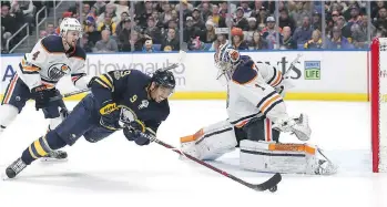  ?? GETTY IMAGES ?? A sprawling Evander Kane of the Sabres tries to knock the puck past Oilers goaltender Laurent Brossoit on Friday night in Buffalo. The Sabres beat Edmonton 3-1 for just their third win at home in 11 outings.