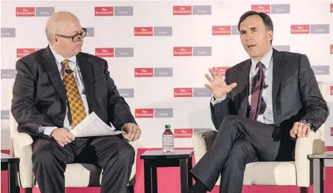  ?? EDUARDO LIMA/THE CANADIAN PRESS ?? Finance Minister Bill Morneau, right, speaks as moderator Matthew Bishop of The Economist looks on at the Canada Summit: Disrupting the Status Quo, held in Toronto on Wednesday. Morneau asked for more time to study the cause of soaring house prices