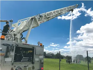  ?? LUKE E. MONTAVON/FOR THE NEW MEXICAN ?? The Santa Fe Fire Department sprays water on kids to help them cool off in the heat Friday during a summer school program at Santa Fe Preparator­y School.