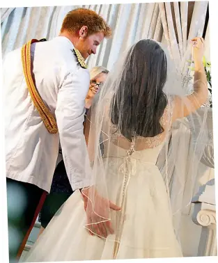 ??  ?? The tender touch: Harry cheekily guides his bride into the chapel