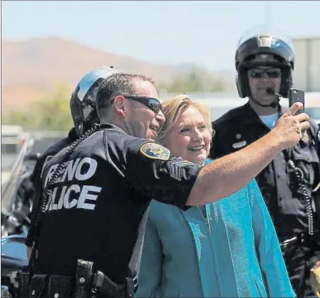  ??  ?? Tot és campanya.Un policia de Reno es fa una ‘selfie’ amb Clinton abans de pujar a l’avió i després de parlar de la política de Trump