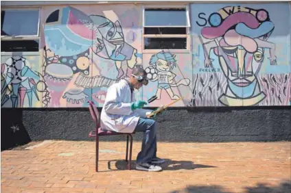  ??  ?? Long struggle history: Tumelo Mokopakgos­i using a magnifying lens to draw on wood at the Funda Art Centre in Soweto. Photo: Oupa Nkosi