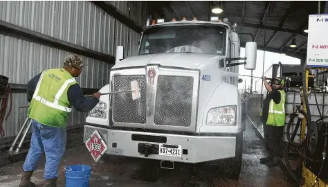  ?? Jerry Baker ?? Brian LaFleur, left, and Stevie Garza wash a truck at Sun Coast Resources. The 33-year-old private Houston company has almost 1,500 employees.