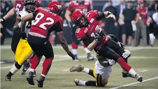  ?? JIMMY JEONG/ THE CANADIAN PRESS ?? Calgary Stampeders Nik Lewis goes up and through the Hamilton Tiger Cats near the end zone in the 2014 Grey Cup in Vancouver on Sunday.